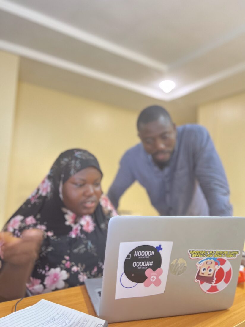 A mentor giving feedback at a learner's screen